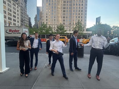 A group of colleagues laughing and walking together on a city street