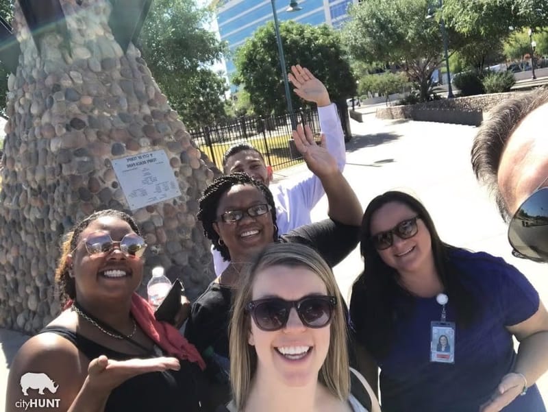 A cityHUNT team taking a selfie next to a stone monument at Tempe Beach Park